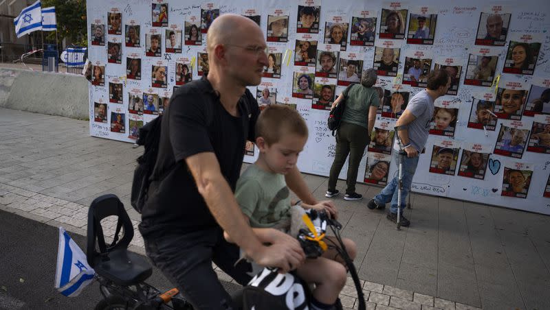 People look at photographs of hostages. mostly Israeli civilians who were abducted during the Oct. 7 Hamas attack on Israel, in Tel Aviv, Israel, on Monday, Oct. 30, 2023.