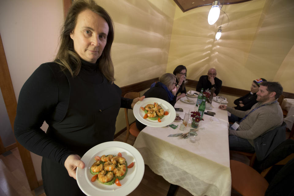 Restaurant owner Patrizia Podetti, center, serves dishes in her Velando restaurant, in Rome, Monday, March 18, 2013. Velando is a favorite dining spot for churchmen, with sleek wooden furnishings, subdued lighting and vaulted, whitewashed ceiling giving an air of a church sacristy. Joseph Ratzinger, recently retired Pope Benedict XVI, often dined there before becoming pope. (AP Photo/Andrew Medichini)