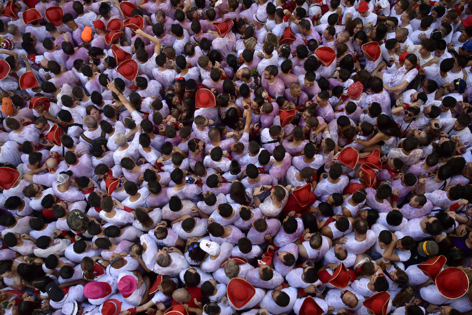 Revellers celebrate while waiting for the launch of the 'Chupinazo' rocket, to celebrate the official opening of the 2019 San Fermin fiestas with daily bull runs, bullfights, music and dancing in Pamplona, Spain, July 6, 2019. (Photo: Alvaro Barrientos/AP)