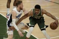 Milwaukee Bucks' Giannis Antetokounmpo tries to drive past Orlando Magic's Ignas Brazdeikis during the first half of an NBA basketball game Tuesday, May 11, 2021, in Milwaukee. (AP Photo/Morry Gash)