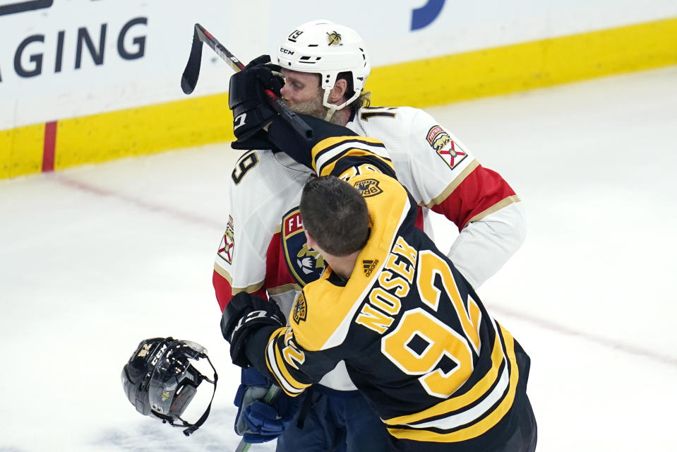 Florida Panthers center Joe Thornton, rear, takes a glove to the face during a fight with Boston Bruins left wing Tomas Nosek (92) during the first period of an NHL hockey game, Tuesday, April 26, 2022, in Boston. (AP Photo/Charles Krupa)