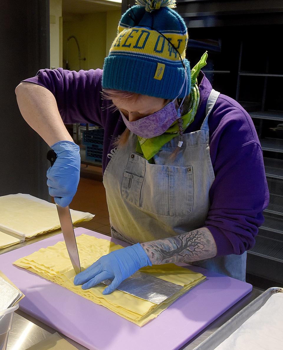 Lisa Rogers cuts pasta to make mushroom lasagna on Thursday at the COMO Cooks kitchen for Pasta La Fata, a vendor at the Columbia Farmers Market.