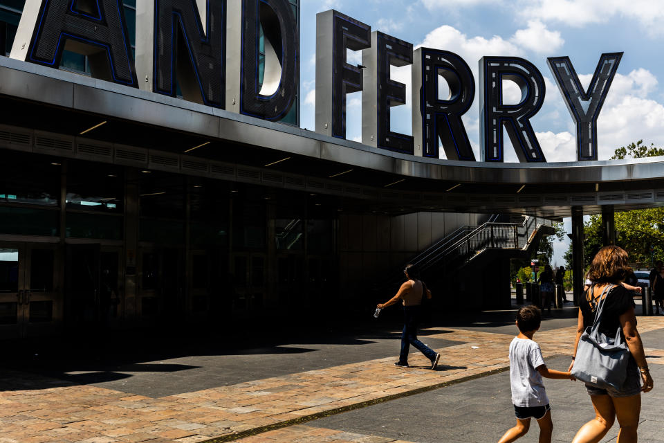 People walk in and out of the Staten Island Ferry's Whitehall Terminal, Thursday, Aug. 4, 2022, in New York. (AP Photo/Julia Nikhinson)