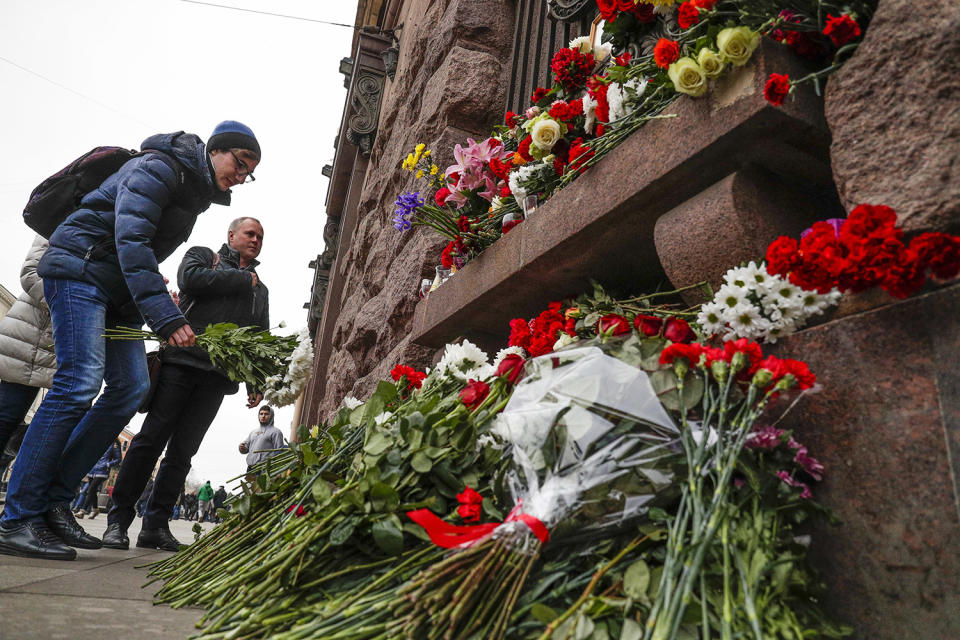 Man placing flowers at memorial