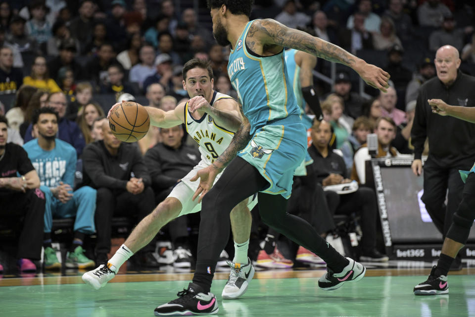 Indiana Pacers guard T.J. McConnell (9) looks to drive past Charlotte Hornets center Nick Richards, center right, during the first half of an NBA basketball game, Sunday, Feb. 4, 2024, in Charlotte, N.C. (AP Photo/Matt Kelley)