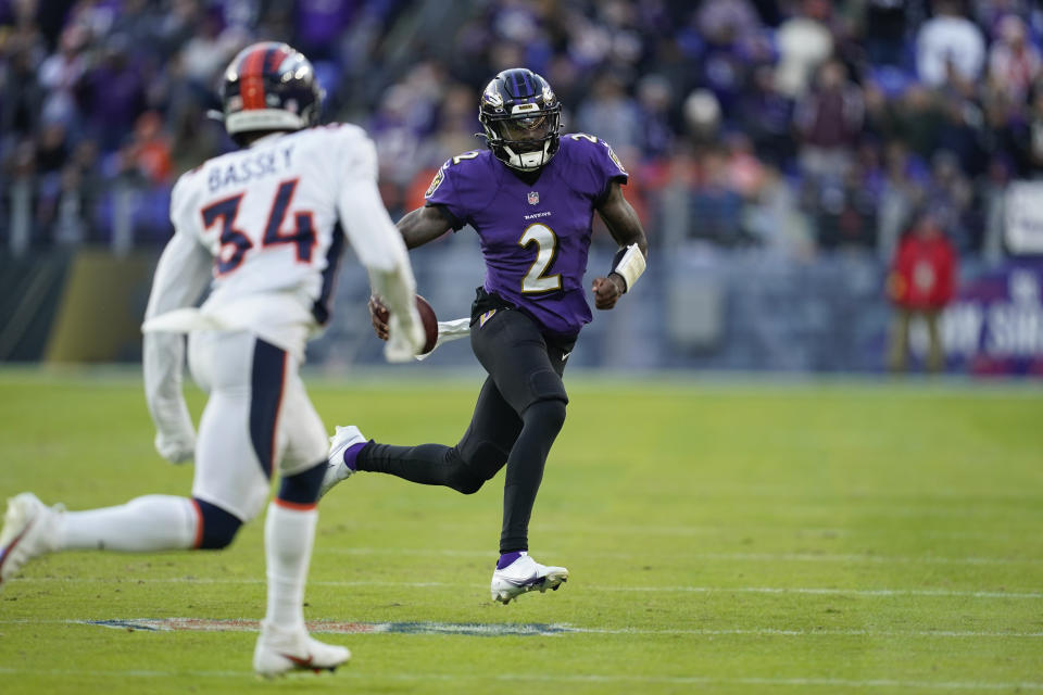 Baltimore Ravens quarterback Tyler Huntley (2) runs with the ball, under pressure from Denver Broncos cornerback Essang Bassey (34), in the second half of an NFL football game, Sunday, Dec. 4, 2022, in Baltimore. (AP Photo/Patrick Semansky)