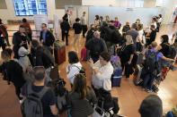 Foreign travelers gather upon arrival at the Haneda International Airport Tuesday, Oct. 11, 2022, in Tokyo. Japan's strict border restrictions are eased, allowing tourists to easily enter for the first time since the start of the COVID-19 pandemic. Independent tourists are again welcomed, not just those traveling with authorized groups. (AP Photo/Eugene Hoshiko)