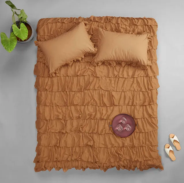 The taupe, <a href="https://fave.co/37dhRtU" rel="noopener" target="_blank" data-ylk="slk:ruffle bed-cover by The Label Life;elm:context_link;itc:0;sec:content-canvas" class="link "><strong>ruffle bed-cover by The Label Life</strong></a> is crafted from cotton percale with voile ruffles.Size: 108 inches X 108 inches. <em>Rs.3,995 on offer.</em> <a href="https://fave.co/37dhRtU" rel="noopener" target="_blank" data-ylk="slk:Buy here!;elm:context_link;itc:0;sec:content-canvas" class="link "><strong>Buy here!</strong></a>