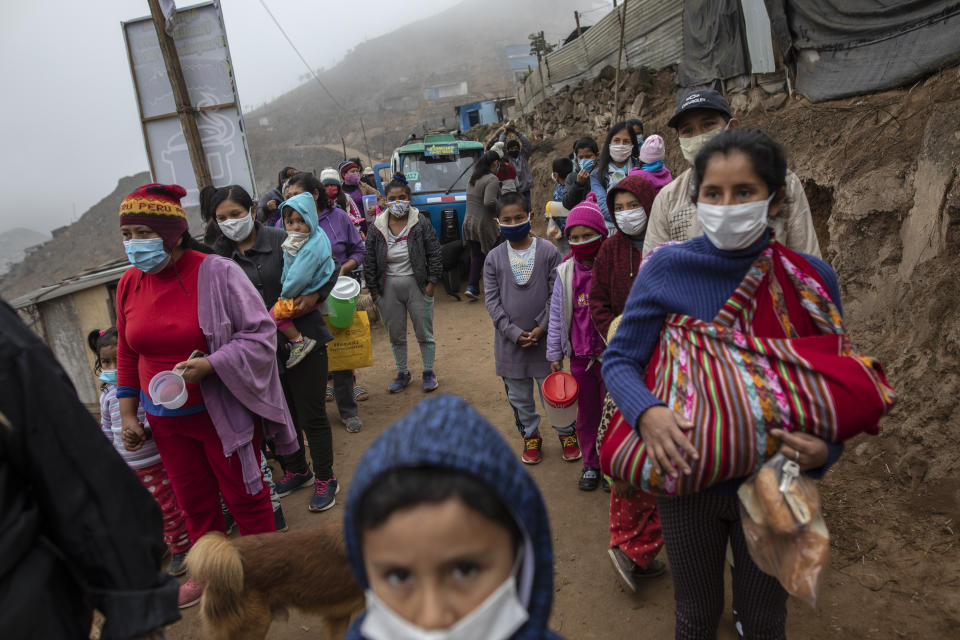 Los residentes hacen fila para recibir un almuerzo gratis de una olla comunitaria en el barrio Nueva Esperanza de Lima, Perú, el miércoles 17 de junio de 2020. (AP Foto/Rodrigo Abd)