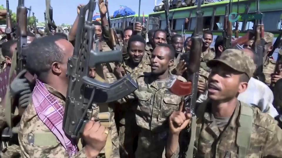 This image made from undated video released by the state-owned Ethiopian News Agency on Monday, Nov. 16, 2020 shows Ethiopian military cheering and dancing in front of cameras on a road in an area near the border of the Tigray and Amhara regions of Ethiopia. Ethiopia's prime minister Abiy Ahmed said in a social media post on Tuesday, Nov. 17, 2020 that "the final and crucial" military operation will launch in the coming days against the government of the country's rebellious northern Tigray region. (Ethiopian News Agency via AP)