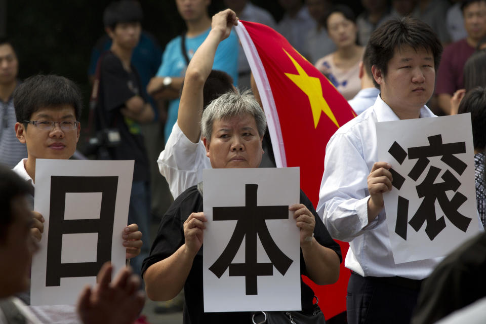 Anti-Japan protesters hold printed Chinese characters, that reads "Japan Get Out," to form a slogan "Japan Get Out of Diaoyu Islands" with other protesters outside Japanese Embassy in Beijing, China, Friday, Aug. 17, 2012. Japan has decided to deport 14 Chinese activists who were arrested this week for landing without authorization on Diaoyu islands, known as islands of Senkaku in Japan, in the East China Sea. The uninhabited islands are controlled by Japan but also claimed by China and Taiwan. (AP Photo/Alexander F. Yuan)