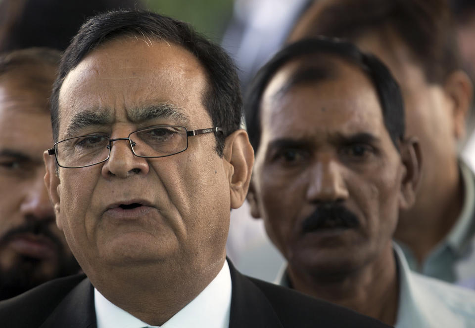 FILE - In this Oct. 13, 2016 file photo, Saif-ul Malook, left, then lawyer of Aasia Bibi, briefs media with Bibi's husband Ashiq Masih outside the Supreme Court in Islamabad, Pakistan. In mid January 2019, Bibi, a Pakistani Christian woman acquitted of blasphemy charges more than two months ago still lives the life of a prisoner, although she was freed from death row by the country’s top court. Malook, who has since been driven into exile fearing for his life, argued that the many inconsistencies in the testimony of her accusers vindicated her. (AP Photo/B.K. Bangash, File)