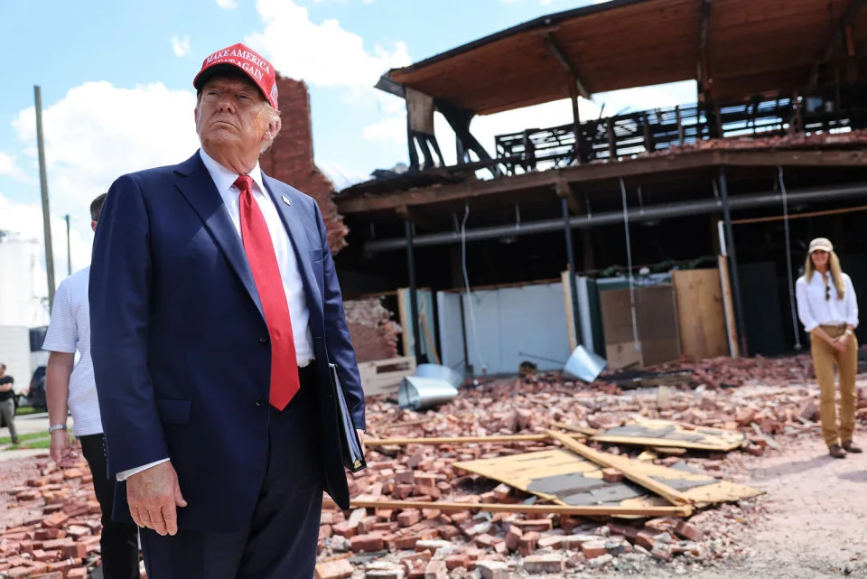 Donald Trump looks around at a debris filled building and street outside (Michael M. Santiago / Getty Images file)