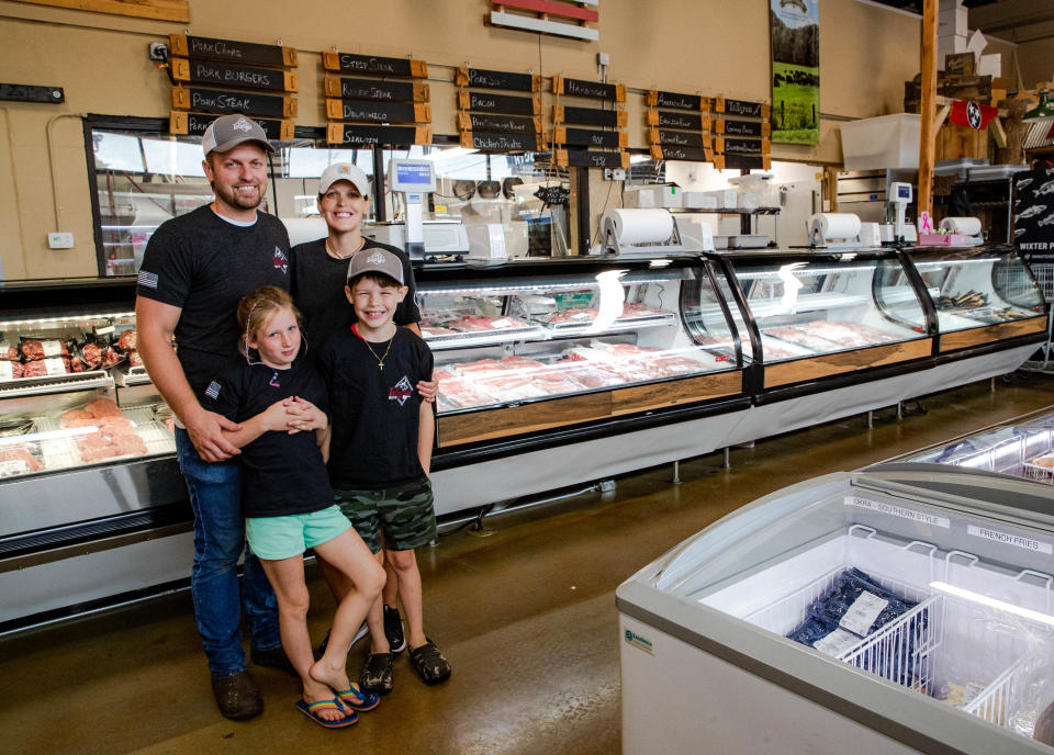 Owner Casey Weber, his wife Savannah and their two children Jack and Eva stand beside the fresh meat counter at Tallgrass Meat Co. in Columbia, Tenn. on Monday July 18, 2022.