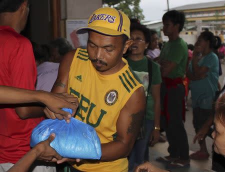 An evacuee received a relief goods after evacuating their homes due to super-typhoon Hagupit in Tacloban city, central Philippines December 5, 2014. REUTERS/Rowel Montes