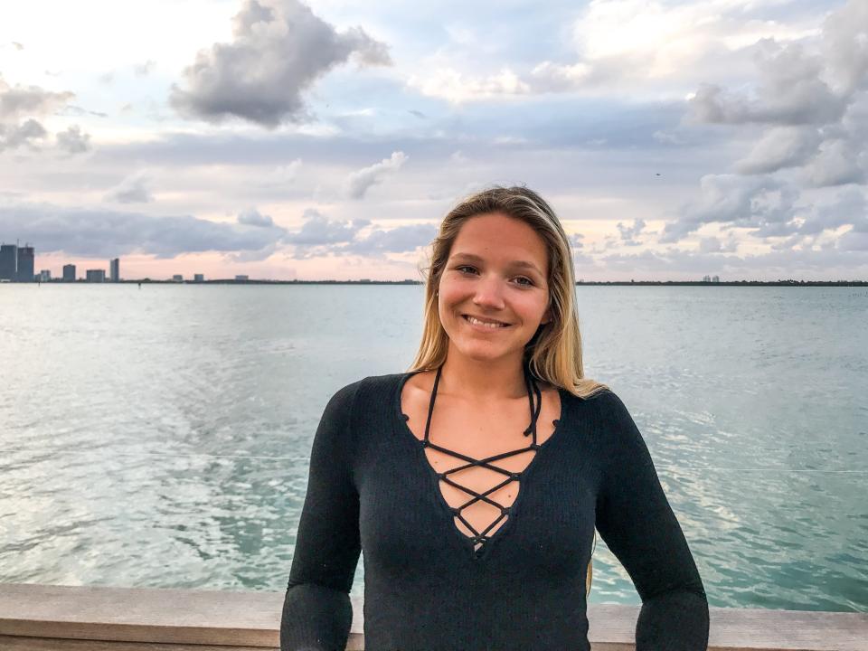 Samantha Shea, young woman stood in front of the Miami beach shoreline.