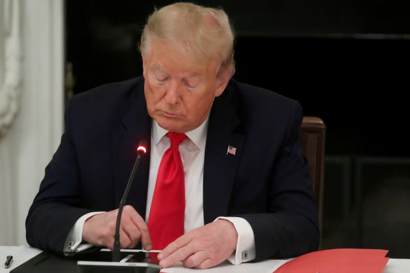 FILE PHOTO: FILE PHOTO: U.S. President Trump uses phone during roundtable discussion on the reopening of U.S. economy at the White House in Washington