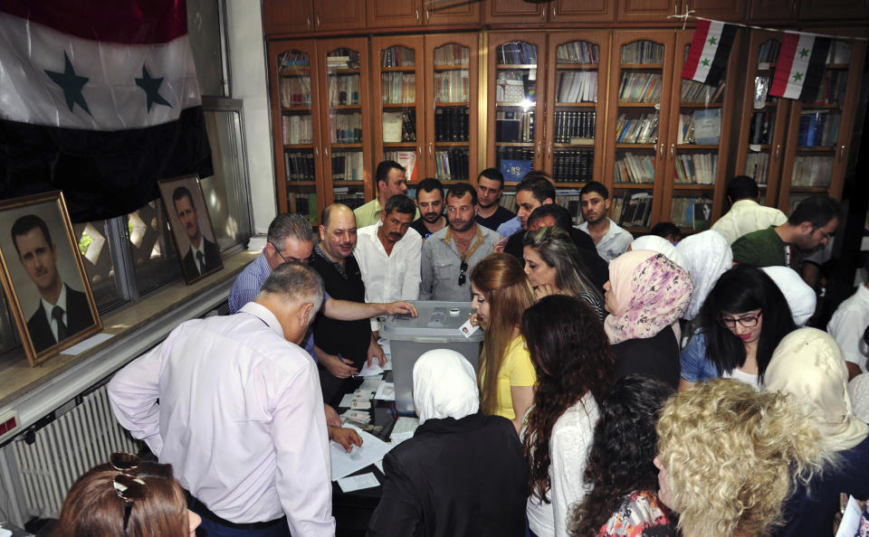 In this photo released by the Syrian official news agency SANA, Syrians cast their votes at a polling station during municipal elections, in Damascus, Syria, Sunday, Sept 16, 2018. Syria is holding its first municipal elections since 2011 amid tensions with the country's self-administered Kurdish region, which is refusing to allow polls. (SANA via AP)