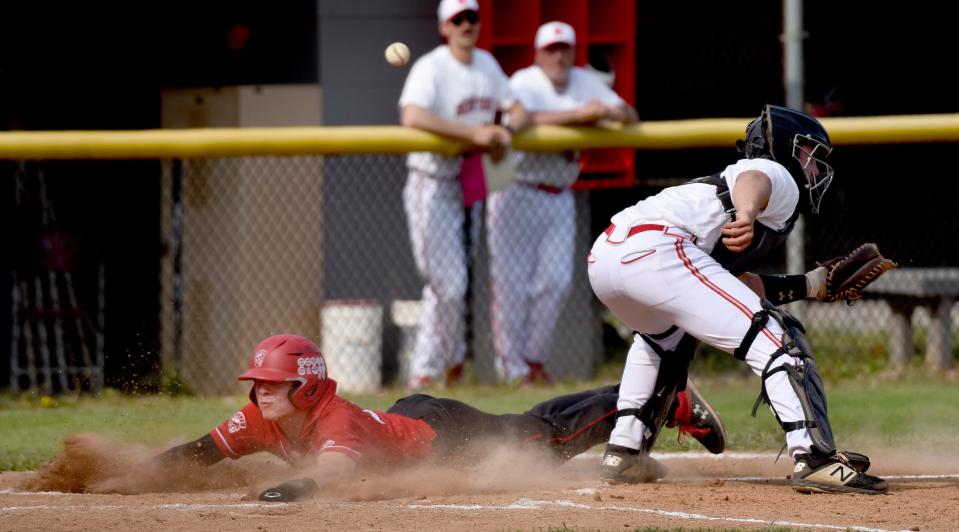 Kellen Roberts of Monroe safe at the plate as the throw to catcher Noah Weiher was off target Wednesday May 11, 2022. The Trojans won 10-0 in five innings.