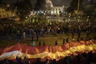 Demonstrators who had gathered to protest lawmakers pushing forward a vote to select an almost-full slate of new magistrates to the Constitutional Tribunal, continue outside Congress after President Martin Vizcarra dissolved the legislature in Lima, Peru, Monday, Sept. 30, 2019. Lawmakers were pushing forward the vote despite Vizcarra's warning that the move threatens his fight against corruption and that he would dissolve the opposition-controlled legislature. (AP Photo/Rodrigo Abd)