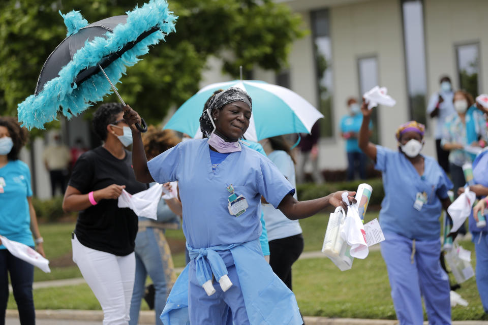 Healthcare workers at New Orleans East Hospital wave handkerchiefs and dance to a jazz serenade, as a tribute for their care for COVID-19 patients, by the New Orleans Jazz Orchestra, outside the hospital in New Orleans, Friday, May 15, 2020. A New York woman collaborated with the New Orleans Jazz Orchestra to put on what she calls a stimulus serenade to give moral support to front-line hospital workers and COVID-19 patients in New Orleans (AP Photo/Gerald Herbert)