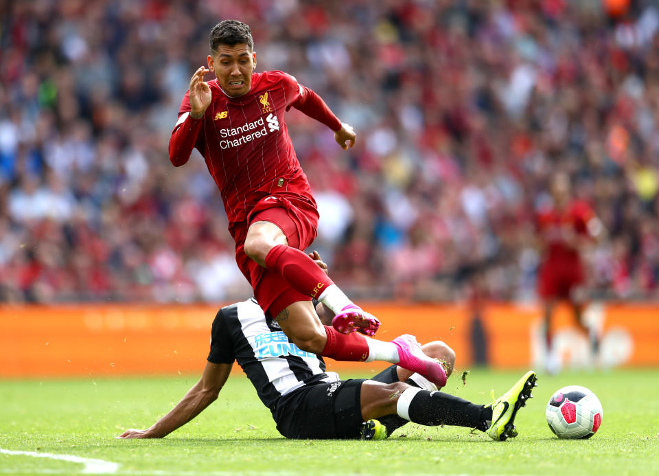 LIVERPOOL, ENGLAND - SEPTEMBER 14: Roberto Firmino of Liverpool is tackled by Isaac Hayden of Newcastle United during the Premier League match between Liverpool FC and Newcastle United at Anfield on September 14, 2019 in Liverpool, United Kingdom. (Photo by Michael Steele/Getty Images)