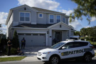 A routine community patrol car drives past as Brazilian supporters of former Brazil President Jair Bolsonaro who also own vacation homes in Encore Resort wait outside the house where he is staying in hopes of greeting him, Monday, Jan. 9, 2023, in Reunion, Fla. As Brazil reels from mobs of rioters swarming its seats of power, its former leader has decamped to a Florida resort, where droves of supporters have flocked to cheer on their ousted president. (AP Photo/Rebecca Blackwell)