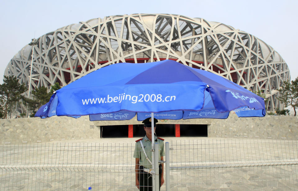 FILE - A Chinese paramilitary police officer stands in the shade on a hot day while guarding the National Stadium, July 23, 2008, in Beijing. Beijing will become the first city to host both versions of the Games. (AP Photo/Robert F. Bukaty, File)