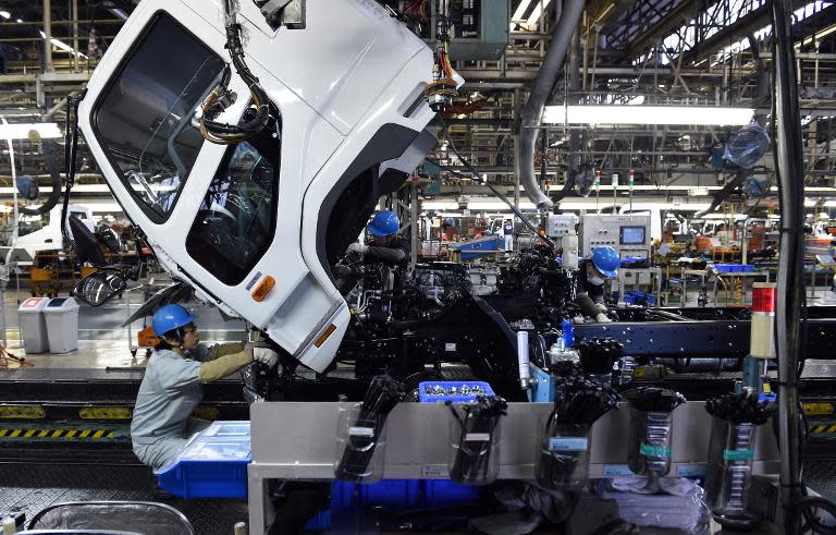 Workers assemble a truck on production line of Mitsubishi Fuso Truck and Bus Corporation (MFTBC) Kawasaki plant, on March 10, 2015