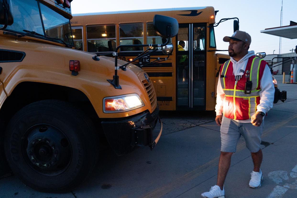 Edgar Arroyo, a trainer at Kansas Central Bus Service, on Wednesday morning looks over the fleet at 200 S.E. 21st St. as drivers prepare to depart on their routes.