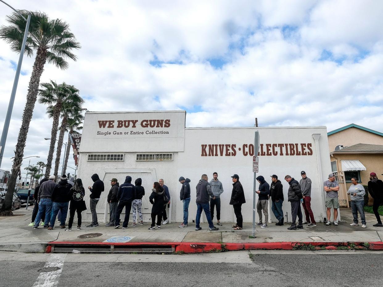 People wait in a line to enter a gun store in Culver City, Calif., Sunday, March 15, 2020. Coronavirus concerns have led to consumer panic buying of grocery staples, and now gun stores are seeing a similar run on weapons and ammunition as panic intensifies. (AP Photo/Ringo H.W. Chiu)