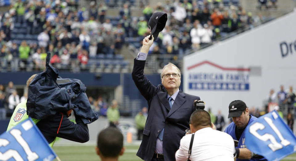In this Sept. 17, 2017 photo, Seattle Seahawks owner Paul Allen waves as he is honored for his 20 years of team ownership before an NFL football game against the San Francisco 49ers in Seattle. Allen died Monday, Oct. 15, 2018, his company Vulcan Inc. announced. (AP Photo/Elaine Thompson)