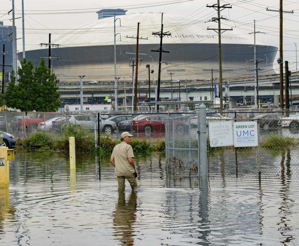 Frank Conforto Jr. walks in the parking lot of the University Medical Center (UMC) with the Mercedes-Benz Superdome in the background on Glavez Street in New Orleans after flooding from a storm, July 10, 2019. (Photo: Matthew Hinton/AP)