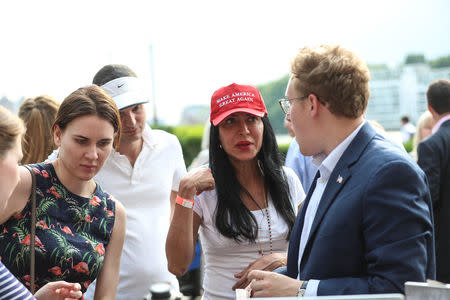 A woman wears a 'Make America Great Again' hat as she talks to people at a Republicans Overseas event in London, Britain, July 4, 2018. REUTERS/Simon Dawson