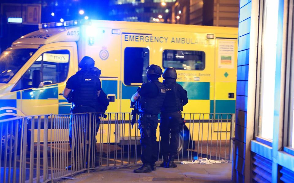 Armed police next to an ambulance after the terrorist attack at Manchester Arena - PA