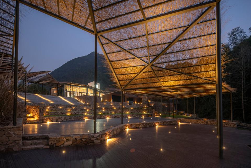 Warm lights along the Flowing Cloud pavilion structure light up the area at night.