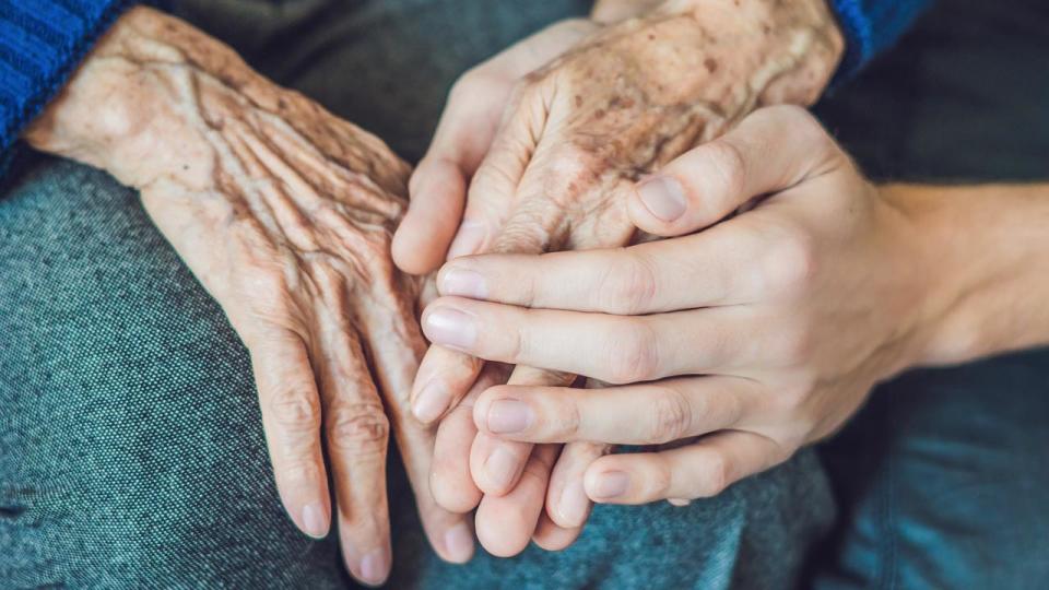 Hands of an old woman and a young man. Caring for the elderly. close up.