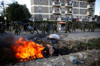 <p>Kenyan police walk past burning tires set on fire during clashes between supporters of Kenyan opposition National Super Alliance (NASA) and police in Nairobi, Kenya, Nov. 28, 2017. (Photo: Baz Ratner/Reuters) </p>