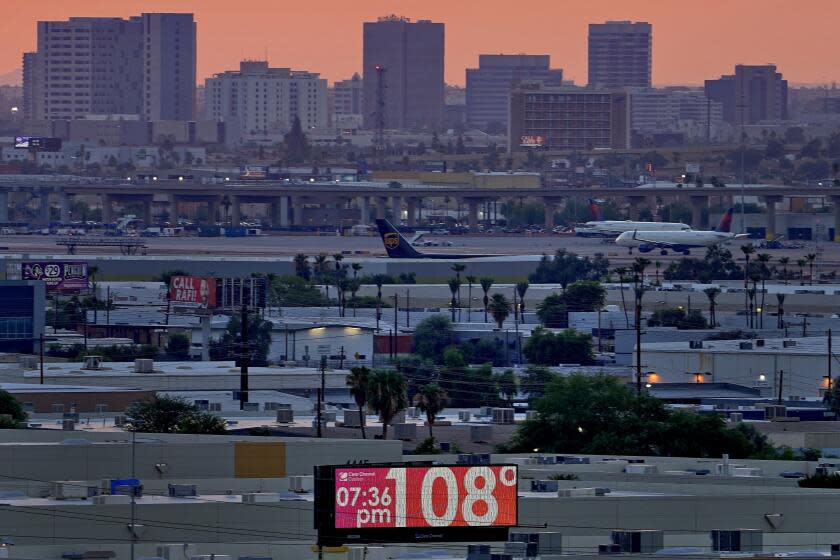 FILE - A sign displays an unofficial temperature as jets taxi at Sky Harbor International Airport at dusk, July 12, 2023, in Phoenix. The historic heat wave continues in Phoenix, but the end may finally be in sight for residents of Arizona's largest city. An excessive heat warning was expected to expire at 8 p.m. Sunday, Sept. 10, and meteorologists were forecasting a high of 106 degrees (41.1 Celsius) on Monday, Sept. 11, and 102 (38.8 C) on Tuesday, Sept. 12. (AP Photo/Matt York, File)