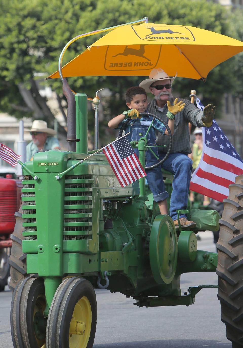 Aamani Fields, 5, drives one of the Topa Topa Flywheelers tractors with his grandfather James Perry during the 15th annual Santa Paula Labor Day Parade in 2019.