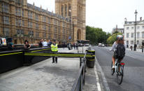 A cyclist passes a police officer standing at the vehicle barrier to the Houses of Parliament where a car crashed after knocking down cyclists and pedestrians yesterday in Westminster, London, Britain, August 15, 2018. REUTERS/Hannah McKay