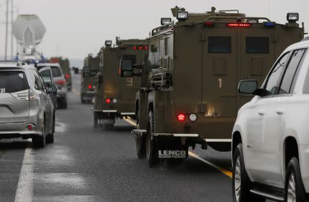 A convoy of law enforcement vehicles drive past members of the media towards the Malheur National Wildlife Refuge outside Burns, Oregon, January 28, 2016. REUTERS/Jim Urquhart