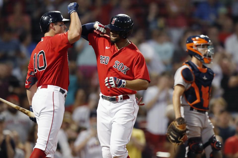 Boston Red Sox's Xander Bogaerts, center, celebrates his solo home run with Hunter Renfroe, left, as Houston Astros' Garrett Stubbs stands at home plate during the fourth inning of a baseball game, Wednesday, June 9, 2021, in Boston. (AP Photo/Michael Dwyer)