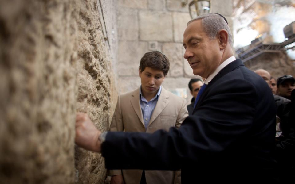 Mr Netanyahu placing a note in the Western Wall, Judaism's holiest site, in Jerusalem - Uriel Sinai/EPA