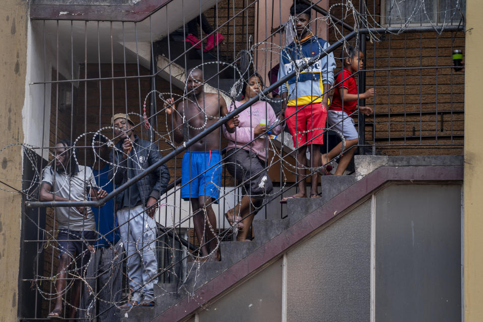 Residents of the densely populated Hillbrow neighborhood of downtown Johannesburg, confined in an attempt to prevent the spread coronavirus, stand on a staircase, Friday, March 27, 2020. South Africa went into a nationwide lockdown for 21 days in an effort to mitigate the spread to the coronavirus. The new coronavirus causes mild or moderate symptoms for most people, but for some, especially older adults and people with existing health problems, it can cause more severe illness or death. (AP Photo/Jerome Delay)