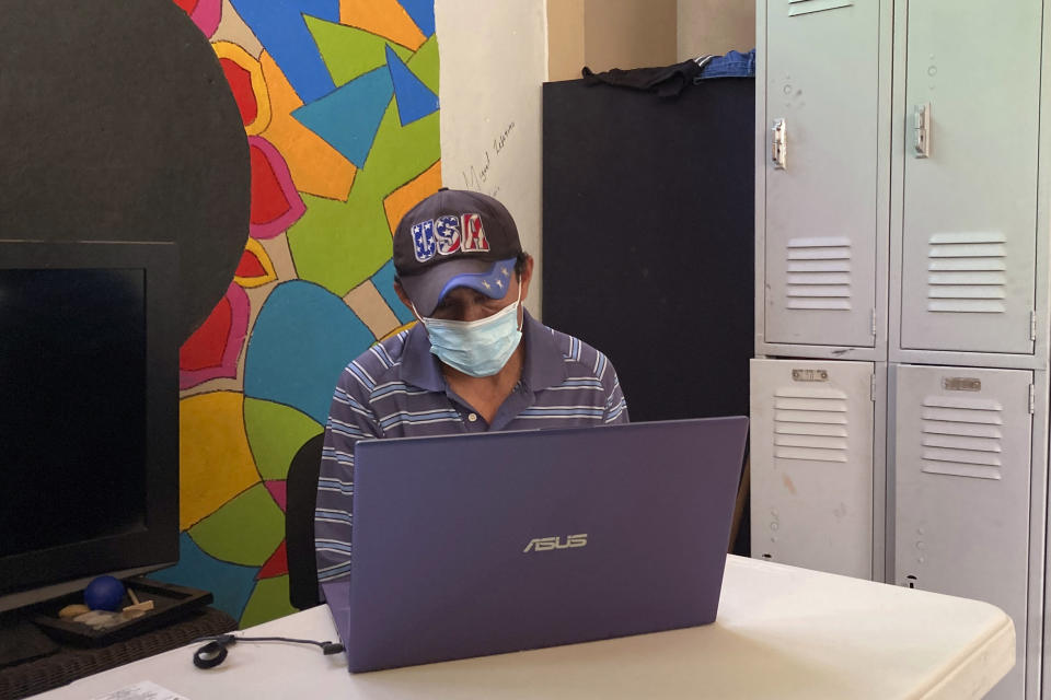 Manuel Antonio Segovia, 44, of El Salvador, speaks with an attorney via a video link on a computer, about his experiences living in Tijuana, Mexico, Saturday, July 3, 2021. Small numbers are allowed into the U.S. every day under a murky system that the Biden administration cobbled together to start opening back up the asylum system in the U.S. Immigration advocates have been tasked with choosing which migrants can apply for a limited number of slots to claim humanitarian protection. (AP Photo/Elliot Spagat)