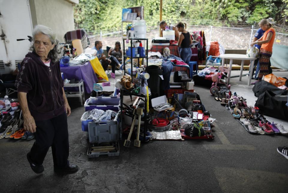 In this Sept. 29, 2019 photo, a woman walks through a secondhand market in Caracas, Venezuela. Residents across Venezuela have increasingly turned to second-hand street markets as migration continues unabated, some that pop up on Sundays or get organized through social media. (AP Photo/Ariana Cubillos)