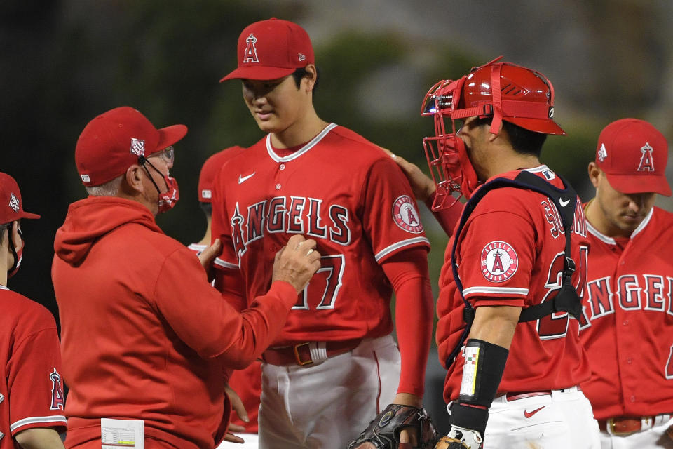 Los Angeles Angels starting pitcher Shohei Ohtani, center, is taken out of the game by manager Joe Maddon, left, as catcher Kurt Suzuki pats him on the back during the sixth inning of a baseball game against the Tampa Bay Rays Wednesday, May 5, 2021, in Anaheim, Calif. (AP Photo/Mark J. Terrill)