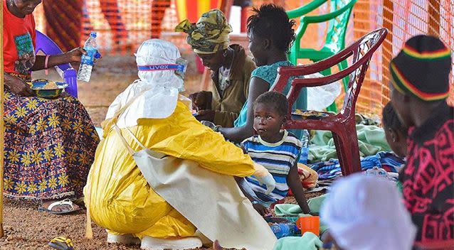 A Doctors without Borders (MSF) medical worker feeds an child suffering from Ebola at an MSF facility in Kailahun, eastern Sierra Leone. Photo: AFP