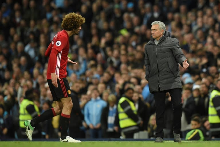 Manchester United's midfielder Marouane Fellaini (L) reacts to Manchester United's manager Jose Mourinho (R) as he leaves the pitch after being sent off during the English Premier April 27, 2017